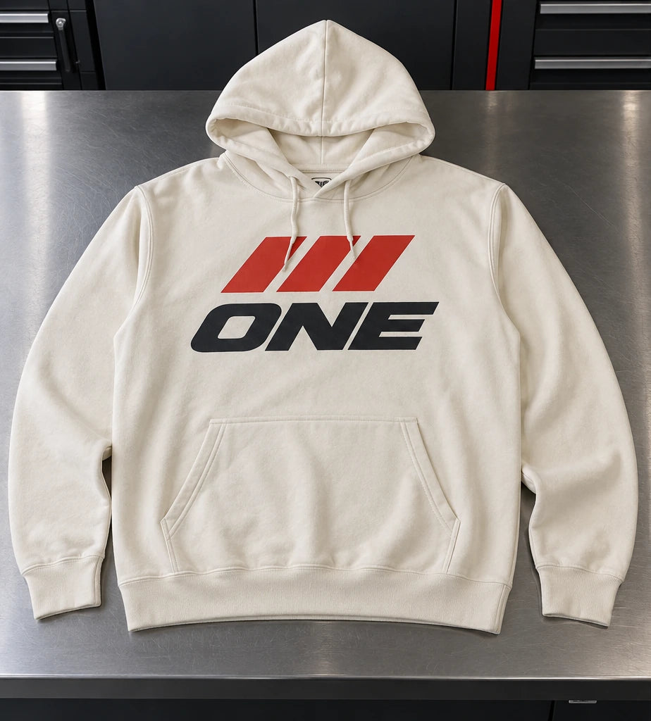 Ivory hoodie with ONE front artwork, PIT CREW sleeve lettering, and an 01 neck label. — Hoodie front