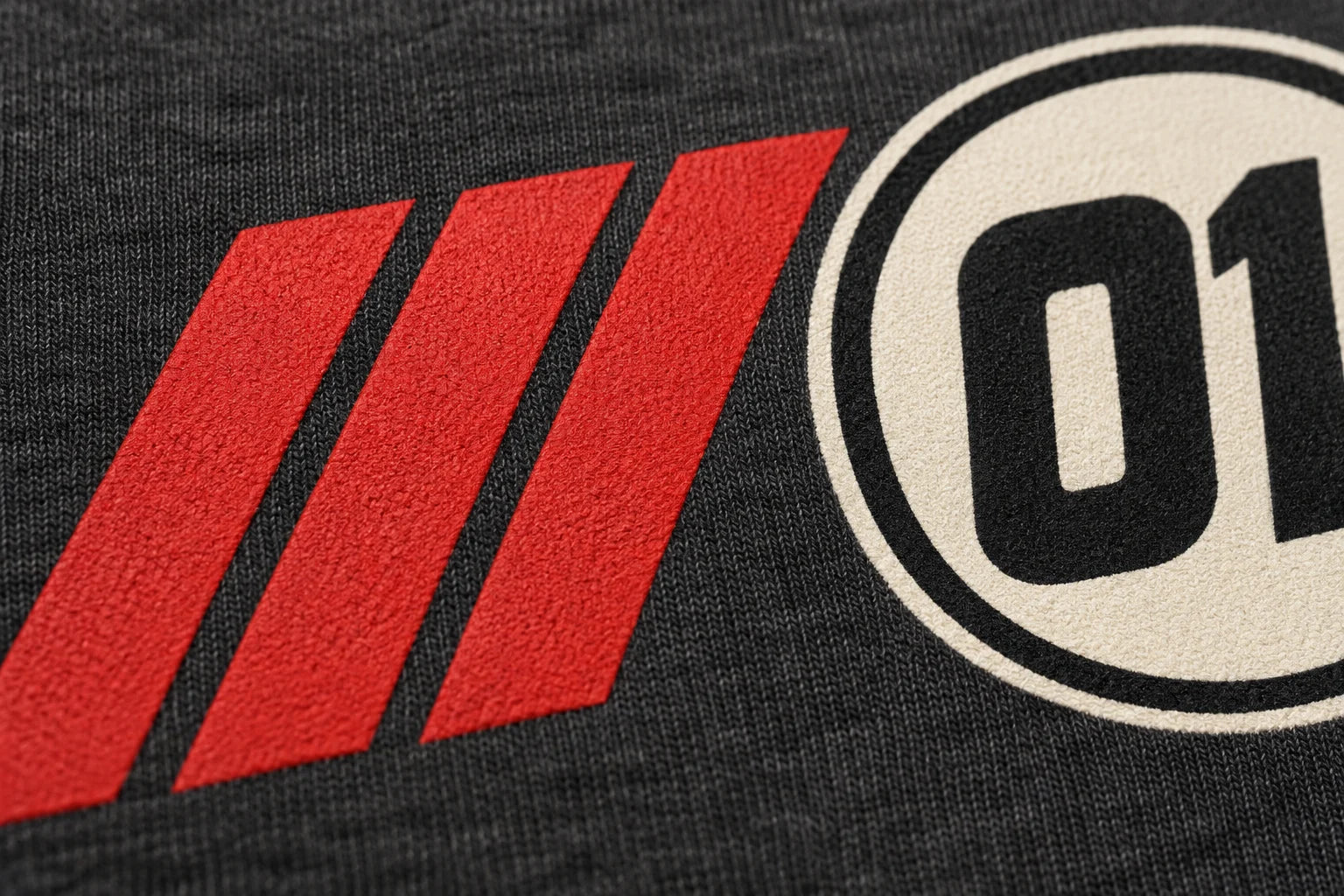 Close-up of an ivory and red transfer print applied to charcoal cotton knit.