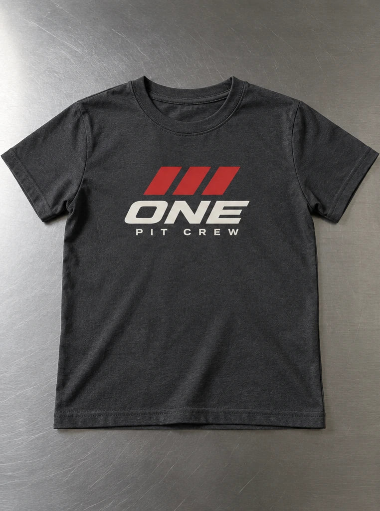 Charcoal youth T-shirt with a compact ONE front graphic beside an ivory shirt pocket with a small 01 logo inside the seams. — Youth-front application